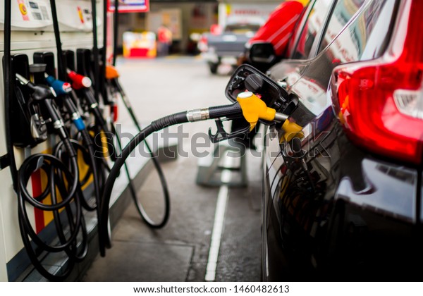 Refilling the\
car with fuel at the gas  station and blurry staff background, \
refilling the car with fuel at the refuel station, the concept of\
fuel energy, Blurry image for\
background.