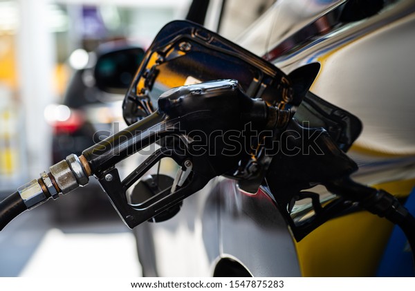 Refilling the\
car with fuel at the gas station and blurry staff background,\
refilling the car with fuel at the refuel station, the concept of\
fuel energy, Blurry image for background.\
