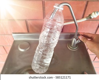 Refilling A Plastic Water Bottle From A Water Cooler