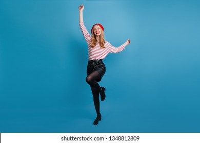 Refined Blonde Girl Dancing And Waving Hands. Studio Shot Of Magnificent French Woman Posing On Blue Background.