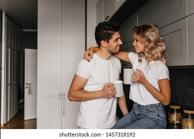 Refined Girl Drinking Coffee With Husband. Relaxed Couple Chilling In Kitchen In Morning.