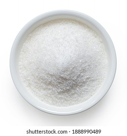 Refined granulated sugar in white ceramic bowl isolated on white. Top view.