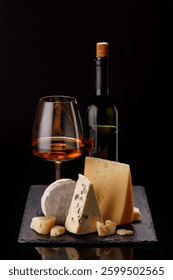 A refined selection of aged cheeses presented on a board, accompanied by a glass of wine, set against a dramatic dark background. A perfect setting for a gourmet indulgence