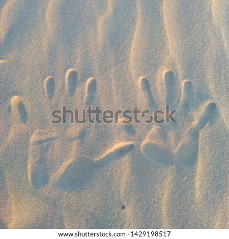 Reflected in the sand, handprints