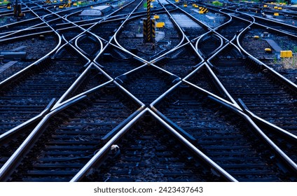 Reflecting symmetrical rails with blue hour twilight. Railway tracks, switches and crossings at a main line station in Frankfurt Main Germany Thresholds, gravel and screws in monochrome deep blue.  - Powered by Shutterstock