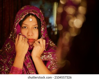 Reflection Of Asian Woman In Indian Dress With Sad Eyes In The Mirror.