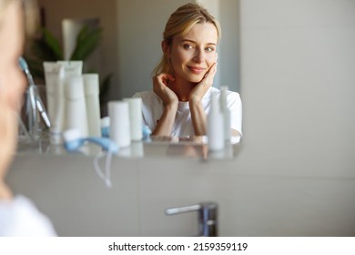 Reflection of attractive Caucasian blonde woman in mirror with perfect skin. Skincare. - Powered by Shutterstock