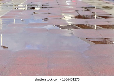 Reflection of a building and blue cloudy sky in a water puddle 