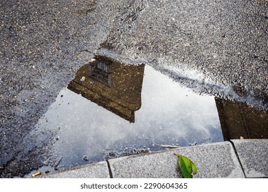 Reflection of a building in a puddle of asphalt in the city. - Powered by Shutterstock