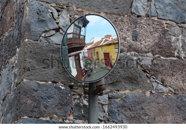 Reflection of a cars and people in outdoor road\
safety mirror