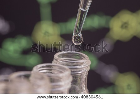 Reflection of chemical formula in water drop on test tube in front of blur chemical formula