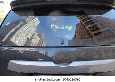 Reflection Of City Houses In The Rear Window Of A Car