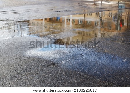 Reflection of city in puddle on pavement