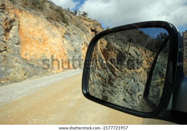  reflection\
of cliffs in car rear view\
mirror
