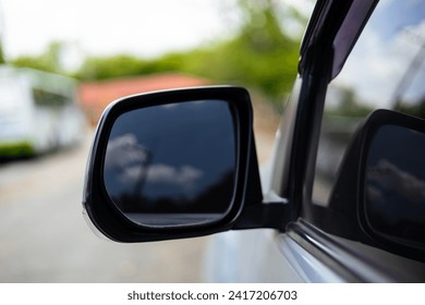Reflection of cloud on side-view mirror of car.