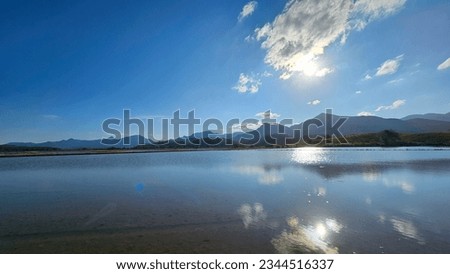 reflection of clouds on the water of irrigated rice fields in the late afternoon.