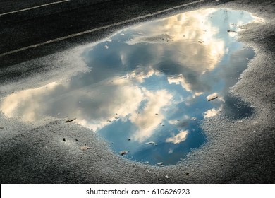 Reflection of clouds in a puddle after a rain. running track
