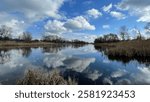 reflection of clouds in a river on a warm, clear day