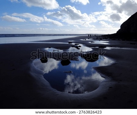 The reflection of clouds in the rockpools on the beautiful beach at Pendine, Carmarthenshire, Wales, UK.