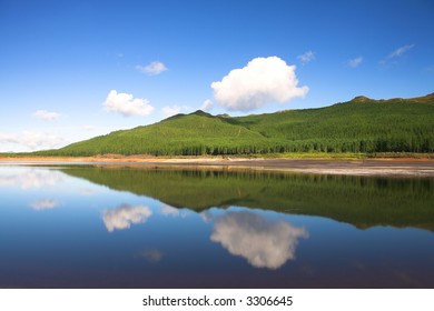 Reflection Of Clouds And Trees In Water Across The Nuweberg Dam In South Africa (actual Reflection, No Filters Used)