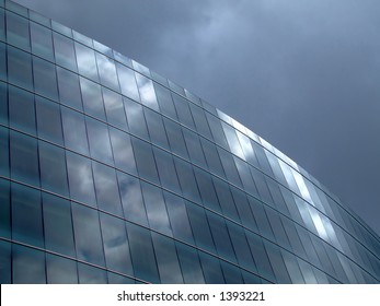 Reflection of cloudy sky in glass wall building