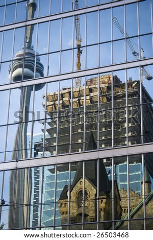   reflection of  cn tower and  construction in  down-town on the glass of  skyscraper