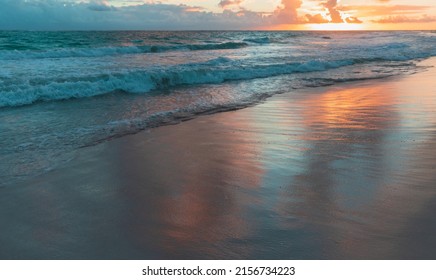 Reflection Of Colorful Sunrise Sky In Wet Coastal Sand Of Bavaro Beach, Punta Cana. Dominican Republic