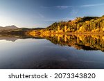 Reflection of colorful yellow autumn trees on water level of lake Liptovska Mara at Slovakia