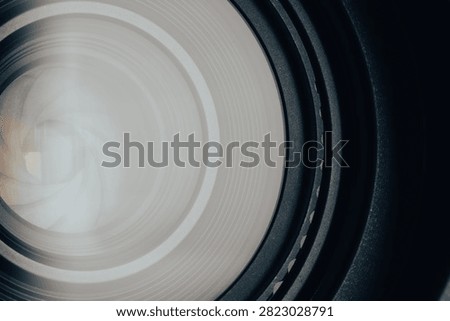 Reflection and Detail inside Camera Lens Glass Elements,Macro,A close-up, detailed photograph looking directly into the front element of a professional camera lens. The image captures the intricate concentric glass rings, coatings, and complex optical elements, with a dramatic flare and starburst effect reflecting from a light source at the center, emphasizing precision engineering and technology.