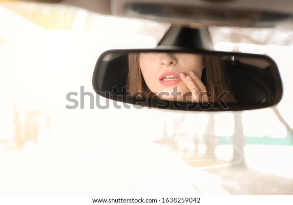 Reflection of driver in\
car rear view mirror