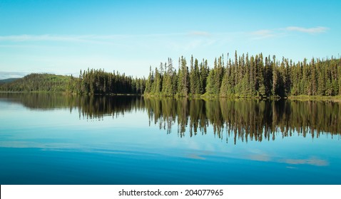 Reflection Of A Forest Into A Calm Lake In Quebec, Canada