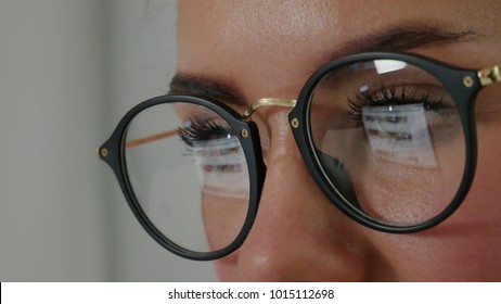 Reflection At The Glasses Of Young Woman: Looking A Site (side View) Beautiful Girl Works On Internet Close Up