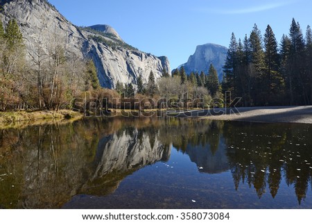 a reflection of half dome of yosemite over merced river