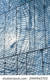 Reflection of hexagonal textured surface of building exterior in windows.	
