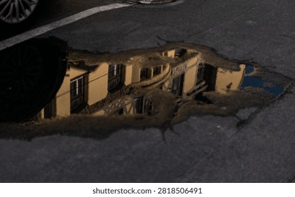 Reflection of Historic Building in Rain Puddle on City Street