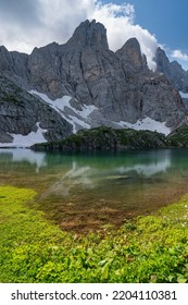reflection in the lake below the alpine summit