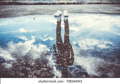 Reflection of man standing near puddle, Style is a reflection of your attitude and your personality,Education begins the gentleman, but reading, good company and reflection must finish him. - Shutterstock ID 708344941