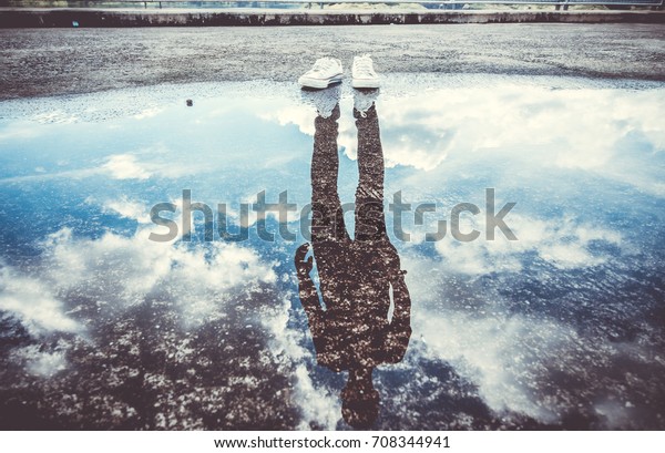 Reflection\
of man standing near puddle, Style is a reflection of your attitude\
and your personality,Education begins the gentleman, but reading,\
good company and reflection must finish\
him.