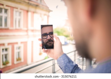 Reflection Of A Man's Face In Mobile Phone