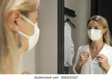 Reflection Of Mature Woman Trying Clothes In Store