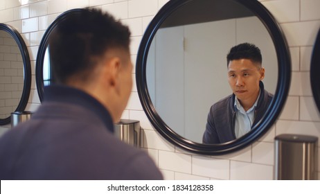 Reflection In Mirror Of Asian Man Washing Face And Hands