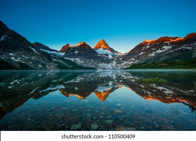 Reflection of mount Assiniboine on Magog lake at sunrise, Alberta, Canada - Powered by Shutterstock