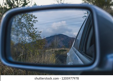 Reflection of the mountain in the car mirror