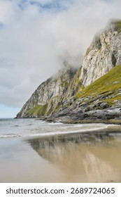 Reflection of mountain cliffs on wet sand, Lofoten Islands