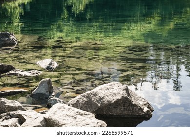 Reflection in the mountain lake of coniferous forest and mountain landscape, clear mountain lake as a mirror - Powered by Shutterstock