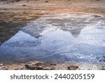 Reflection of a mountain range with snowfields and glaciers in the blue water of Lake Kulikalon in the Fan Mountains in the morning in Tajikistan, Tien Shan highlands