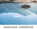 Reflection of a mountain range with snowfields and glaciers in the blue water of Lake Kulikalon in the Fan Mountains in the morning in Tajikistan, Tien Shan highlands