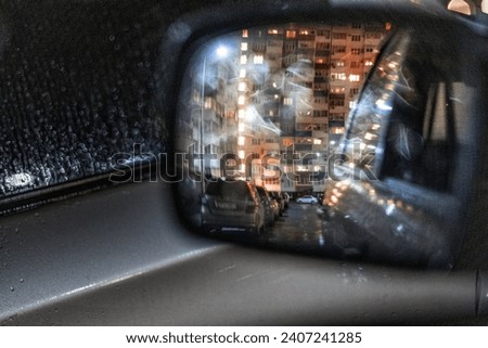 Reflection of the night city in the rearview mirror, blurred background, bokeh
