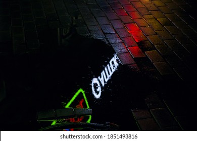 Reflection of night lights in puddle on sidewalk