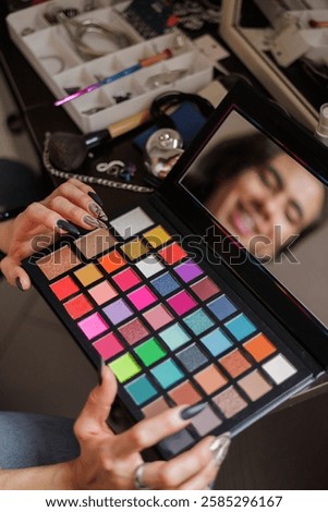 Reflection of a non-binary person in the mirror putting on makeup before going to work